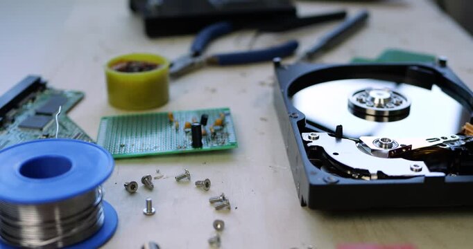 Professional IT technician workspace with electronics repair tools, including soldering iron, multimeter. hard drive components on workbench. Computer repair, technical support. Hardware diagnostics.