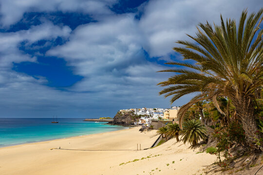 Panoramic view of a sandy beach with turquoise ocean under a blue sky, Morro Jable, Canary Island, Fuerteventura, background or wallpaper for your project   