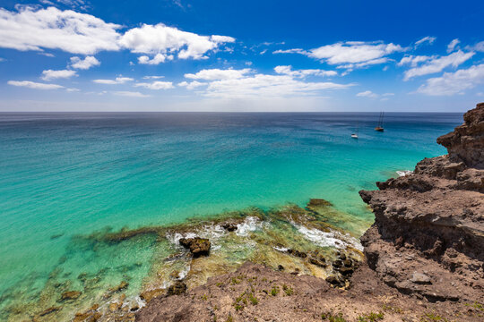 Panoramic view of a sandy beach with turquoise ocean under a blue sky, Morro Jable, Canary Island, Fuerteventura, background or wallpaper for your project   