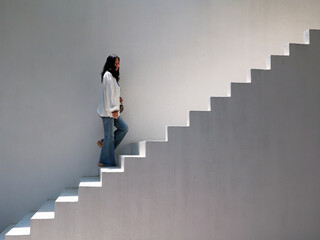 Young woman walking up stairs step by step
