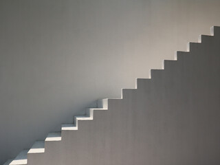 Modern building exterior with outdoor spiral staircase on concrete wall.