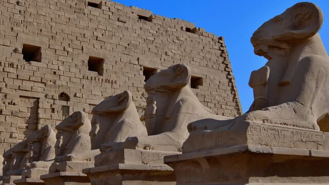 Karnak Temple in Luxor, Egypt. Ram-headed sphinx alley at Karnak Temple. Ancient stone statues of Amun god along sacred processional avenue.