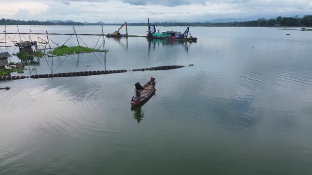 4K Aerial Drone View of Traditional Fisherman Casting Net from Wooden Boat on Lake in Malang Indonesia