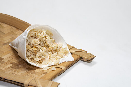 Fried flattened rice on Bamboo Tray. Fried spicy Cheera flattened rice cereal penult traditional Bengali snack mix in enamel tin bowl.