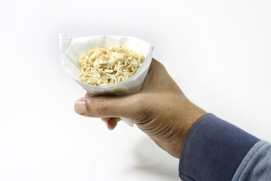 Fried flattened rice on Bamboo Tray. Fried spicy Cheera flattened rice cereal penult traditional Bengali snack mix in hand.