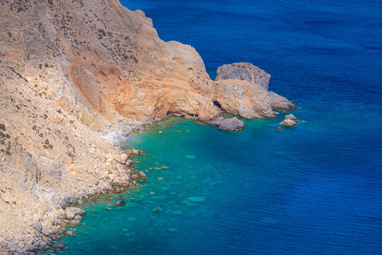 Ochre cliffs and turquoise cove on Amorgos