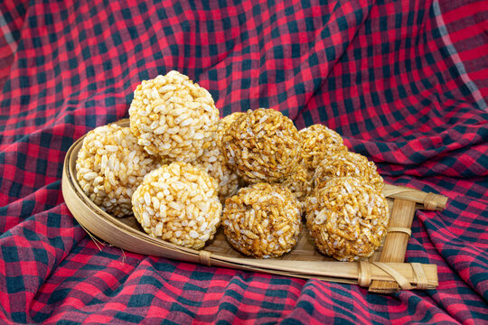 Bengali Traditional Puffed Rice Balls is a sweet made using puffed rice mixed with jaggery, Murmura Laddoo, Churmura Laddoo or Pori Urundai. flattened rice sweet ball or Chirar moa on bamboo tray.