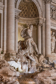 Oceanus statue atop a shell chariot with tritons and seahorses at Trevi Fountain, illuminated at night, showcasing Baroque Roman sculpture and historic architecture