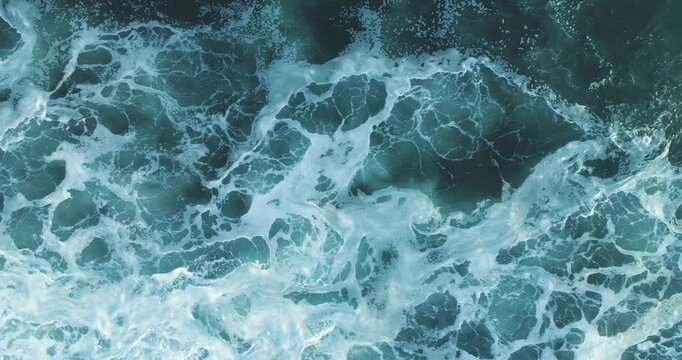 Abstract video background of the restless sea with dramatic waves and white water textures