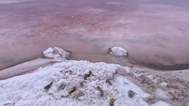 The Kuyalnik Estuary in the Odessa Oblast, Ukraine: black dust deposited on the shoreline covered with white table salt crystals of sodium chloride (NaCl)