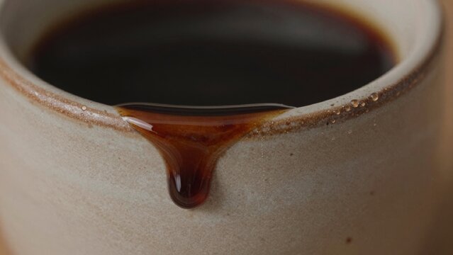 Close-up ceramic cup dark glossy surface appears made stoneware porcelain light beige color smooth texture sli