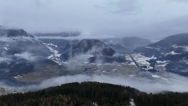 Cinematic Drone Forward Flight Over Alpine Pine Forest with Vipiteno Town in the Valley, South Tyrol
