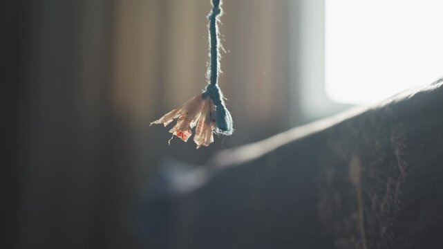 Bright morning scene. Light reveals aged fabric and dust. Early daylight illuminates worn textile and surroundings. Sunlight highlights fragile threads and dusty environment at dawn