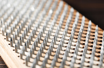 Fototapeta premium Nail standing practice. Sadhu board on brown background, closeup