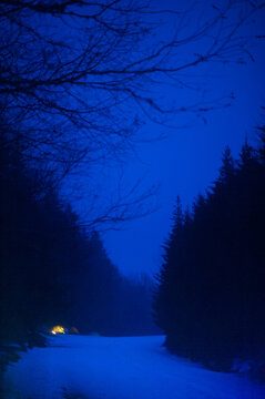 Glowing tents at night along a mountain road in winter