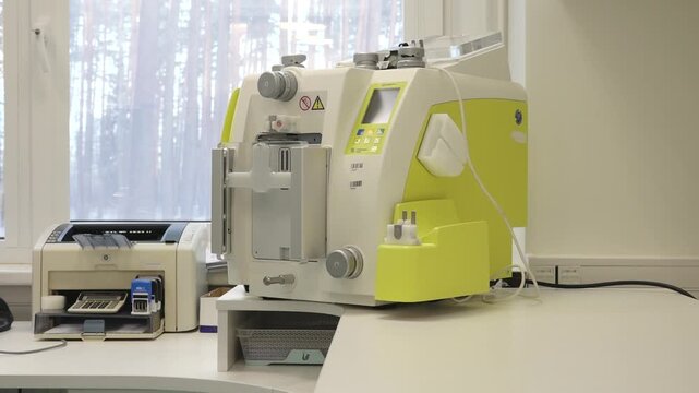 Blood donation equipment in a medical facility, showcasing a blood separator machine with visible components and a clean workspace
