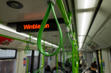 Green handles inside train with Wimbledon sign © MarshallChan