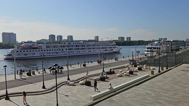 MOSCOW - JUL 26 , 2025: Large cruise ship is docked at a pier. The pier is filled with people walking around and enjoying the view