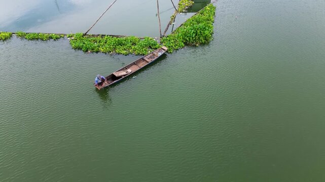 4K Aerial Drone View of Traditional Fisherman Casting Net from Wooden Boat on Lake in Malang Indonesia