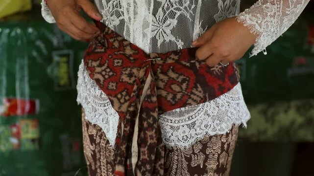 A woman adjusts a sacred geringsing textile, handcrafted using the double ikat technique and hand-dyeing in Tenganan village, Bali, Indonesia, December 4, 2025.