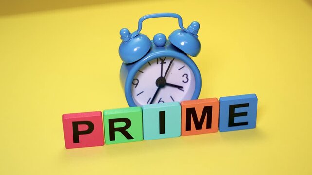 Blue alarm clock showing prime time concept on yellow background.