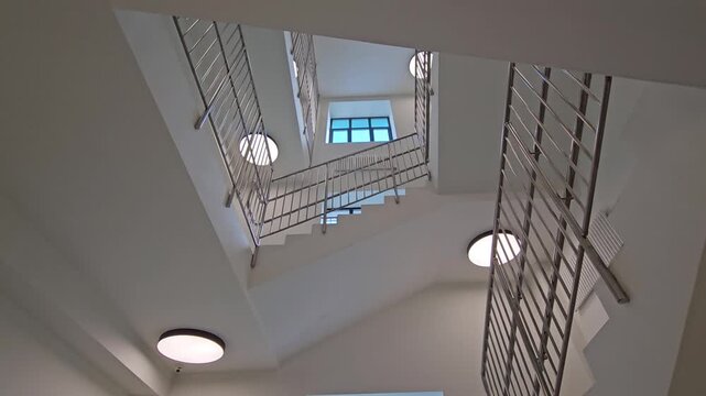 Staircase with a blue and white stripe on the wall. The staircase is numbered 2. The staircase is made of metal