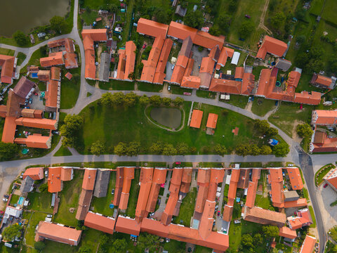 Topdown aerial view of Hola&scaron;ovice village in South Bohemia, Czech Republic, featuring traditional red-roof houses, farmland, and historic rural layout in summer
