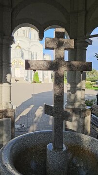 DIVEYEVO - AUG 27, 2025: Large stone cross is in a fountain. The fountain is surrounded by stone pillars near church Seraphim-Diveyevo Trinity Monastery.
