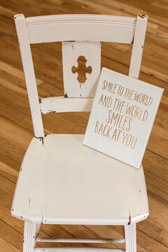 White Chair with Inspirational Smile Quote Sign in Warm Interior
