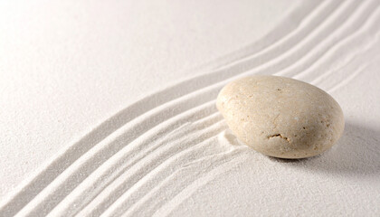 Obraz premium Single smooth light brown stone rests on raked white sand with gentle wave patterns