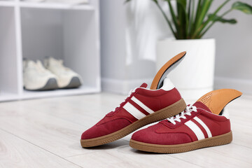 Naklejka premium Pair of shoes with orthopedic insoles on floor indoors. Space for text