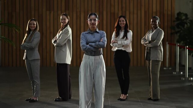 Empowered multi ethnic businesswomen team walking forward with leadership towards the camera in a corporate office lobby
