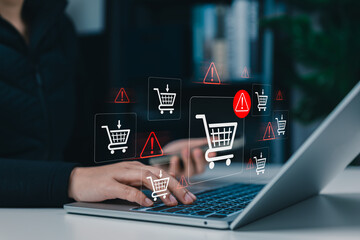 E-Commerce Warning and Shopping Cart Risk Concept. Woman using laptop with shopping cart icons and alert symbol, online purchase issues, checkout risk, transaction warning, ecommerce security concerns © Sandwish