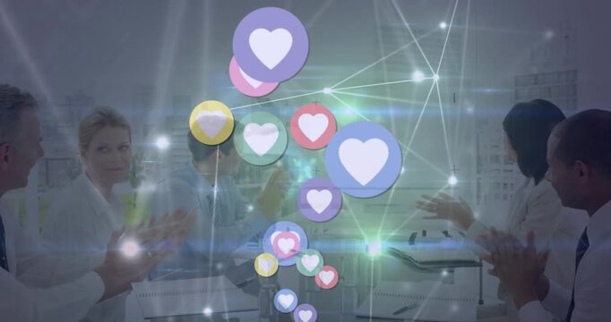 Animation of heart in circles, connected dots over diverse coworkers applauding on achieving target
