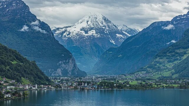 Time lapse, a steep, forested valley leads up to the sharp, pyramidal summit of Bristen. Reuss valley, canton Uri, Switzerland.
