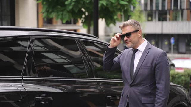 Ault man walking near his car in the city. Slow motion