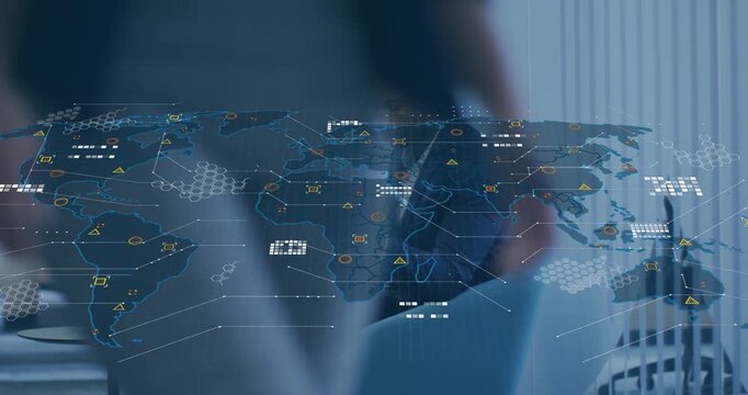 Animation of world map over african american businessman with laptop using smartphone at office