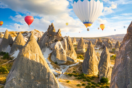 Hot air balloons flying over rocks near Goreme village. Cappadocia. Turkey