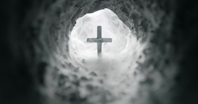 Cave filled with fog slowly revealing a crucifix in the opening of the empty tomb. Symbolic of the resurrection of Jesus Christ. Good Friday, He is Risen concept. Symbolizing faith or god in heaven.