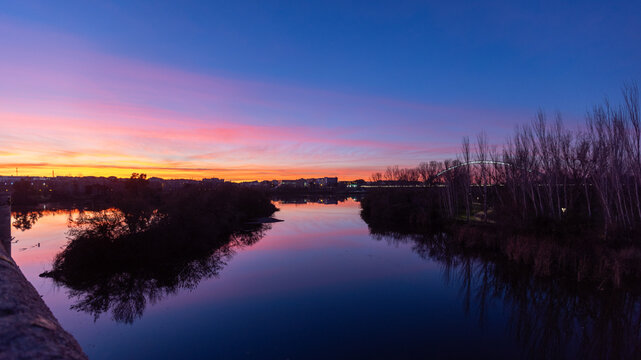 Peaceful sunset view of the Guadiana River as seen from the Puente Romano bridge in Merida Spain ESP