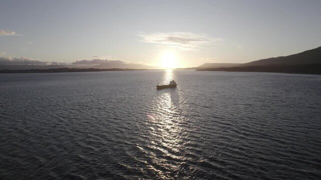 Aerial video of a ship at sea sunrise