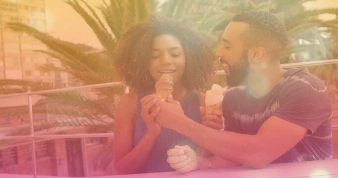 Man extending ice cream cone toward woman, woman taking bite, rooftop ad capturing playful sharing