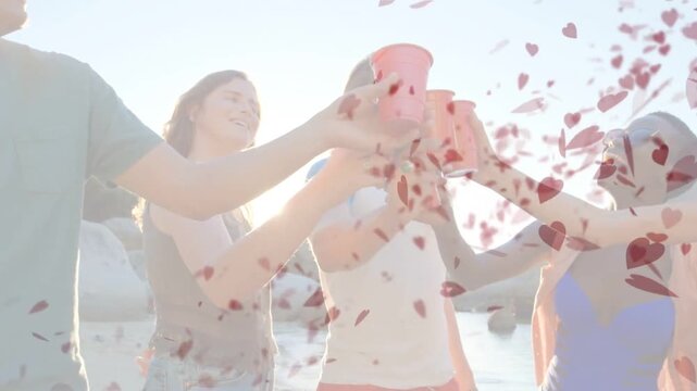 Vertical video: Toasting 5 pals in swimwear lifting red cups at shore, clinking then hearts filling