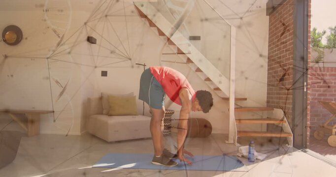 Starting on mat at home, man in red sleeveless top gradually bending forward with water bottle