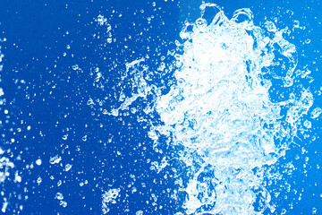 公園の噴水の水のアップと青い紙の背景 爽やかで涼しいイメージ