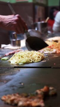 Close-up of chef preparing traditional okonomiyaki in Japan