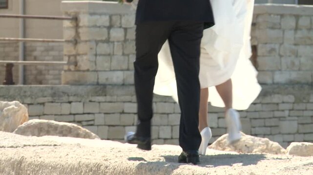 Coppia di giovani sposini camminano a piedi nel centro storico di Giovinazzo in provincia di Bari