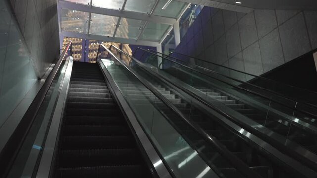 Escalator moving up from underground to the street. Wide shot in Shopping Center