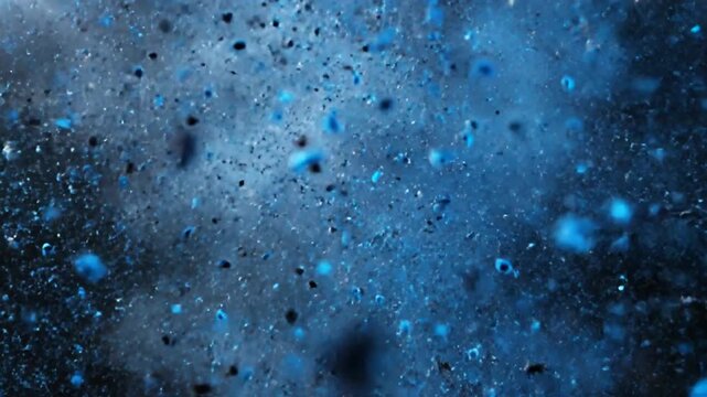 Blue powder explosion, dust cloud bursting in slow motion against black background