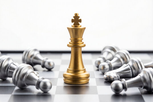 Golden chess king triumphant over fallen silver pieces on chessboard